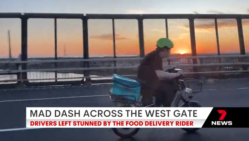 Drivers on the West Gate have been left gobsmacked by a food delivery driver making a mad dash across the bridge. Vision uploaded to social media appears to show the man given an escort by a silver taxi. #7NEWS