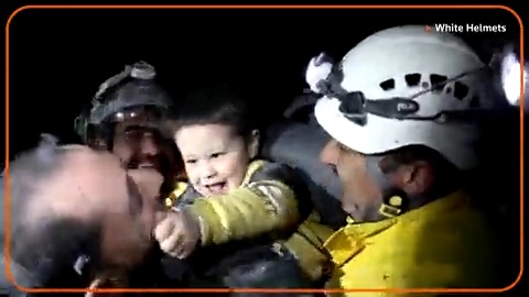 A young Syrian boy smiled and started to play with rescue workers who pulled him from the rubble of a building that was destroyed following deadly earthquakes in Turkey and Syria