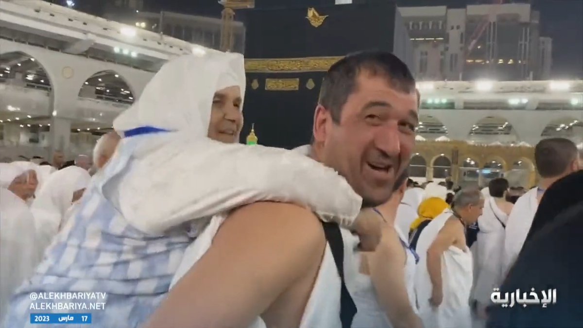 في مشهد يعكس البر بالوالدين.. معتمر يحمل والدته على ظهره ويطوف بها في المسجد الحرام. -
