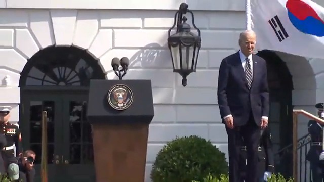 Joe Biden walks on stage right past the podium