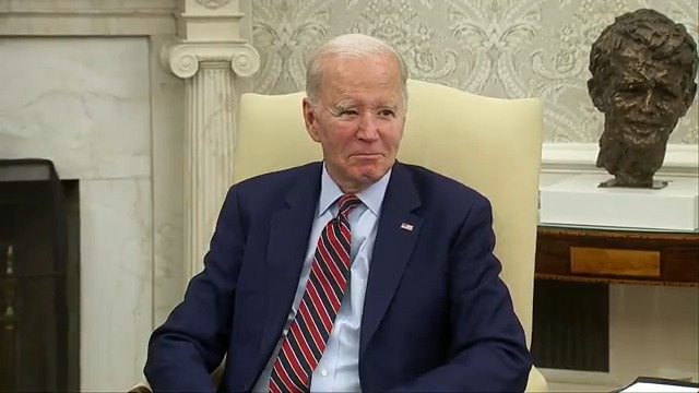 Refusing to take any questions from the press, Biden sits and stares as his staff herds them out of the room