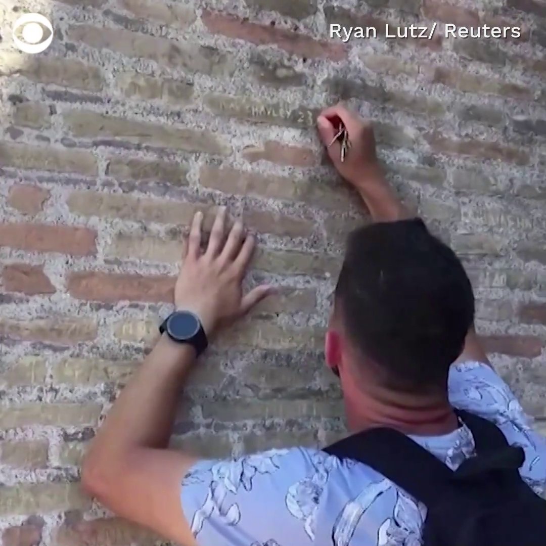 A man was filmed by a bystander using keys to carve his fiancรฉe's name onto the Colosseum in Rome, Italy.
