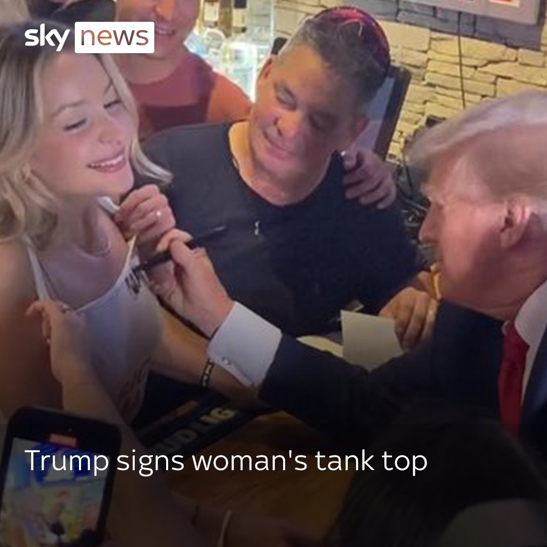 Donald Trump signs woman's tank top during campaign visit to Iowa restaurant. Read more: