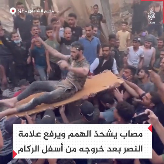 فلسطيني مصاب يخرج من تحت الأنقاض رافعًا علامة النصر بعد استهداف منزله في مخيم الشاطئ بقطاع غزة