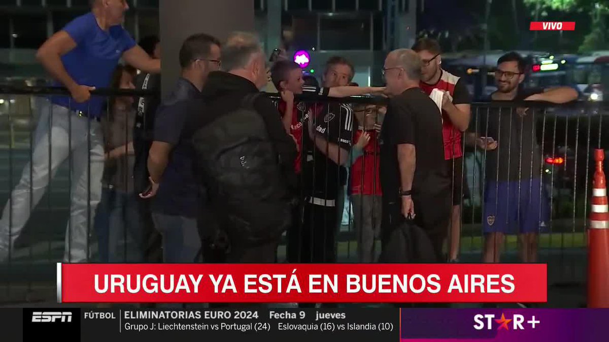Marcelo Bielsa signs a Leeds United shirt presented to him by Newell's fans as his Uruguay squad arrive in Buenos Aires.