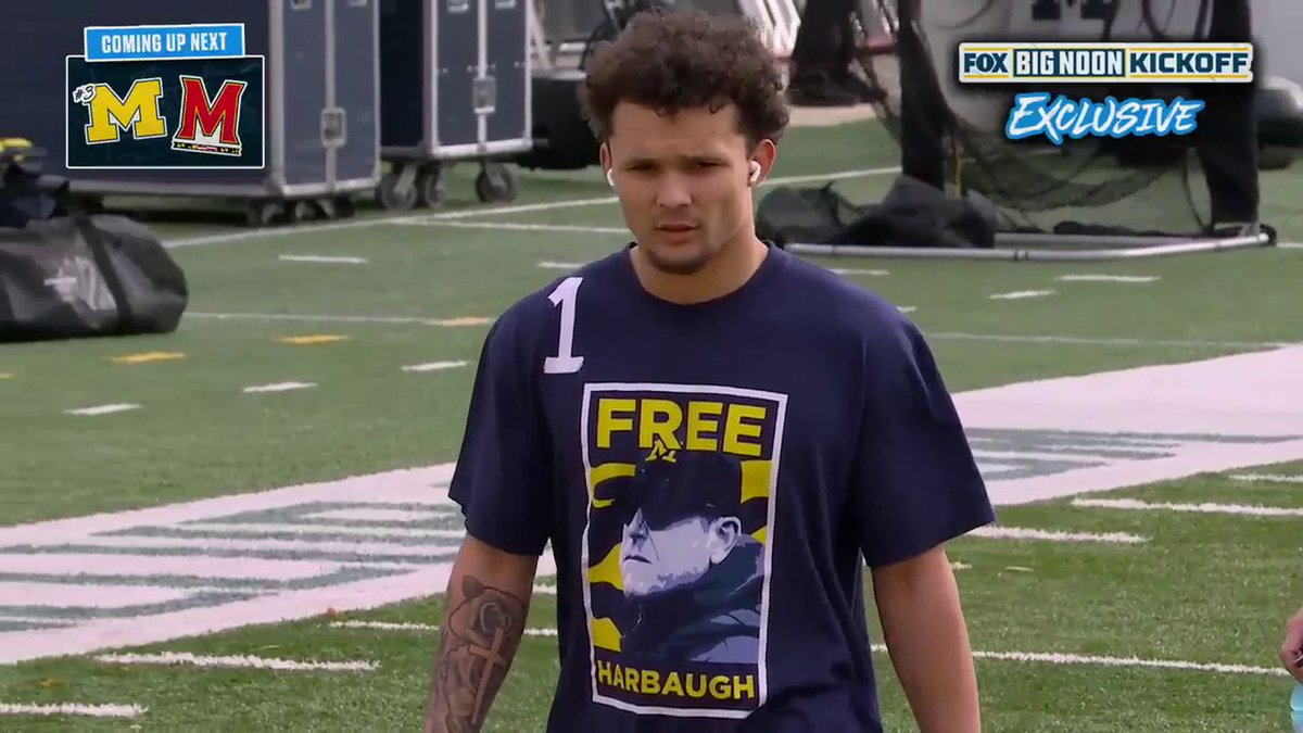 A Michigan player is wearing a 'Free Harbaugh' shirt during warmups