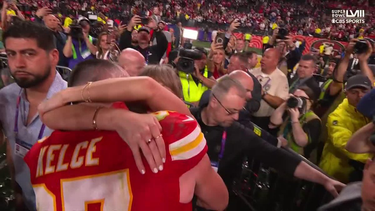 Taylor Swift and Travis Kelce celebrating the Chiefs #SuperBowl win on the field.
