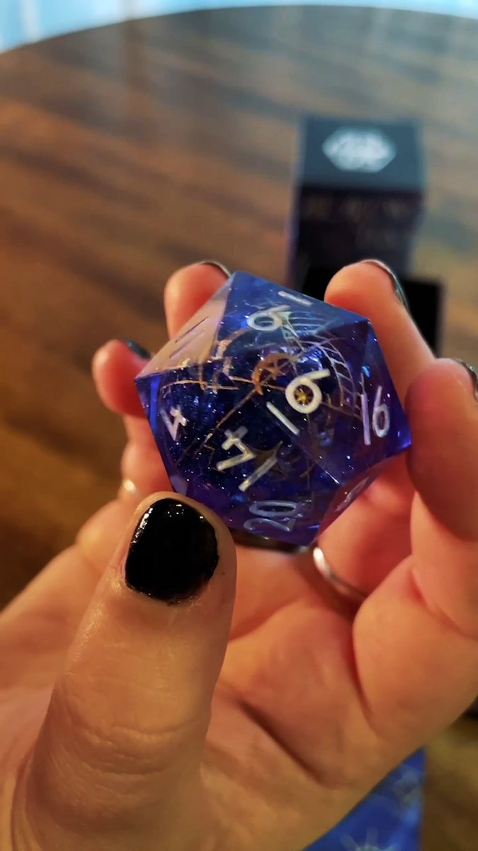 Coming soon to our US, EU and UK Shops! 🎲 ✨ With a swirling liquid core of glittering stars, our stunning Luxon Beacon inspired dice collab with Everything Dice 🎲✨ is complete with golden dunamancy sigils and gorgeous box art by anna zee featuring Essek Thelyss himself!