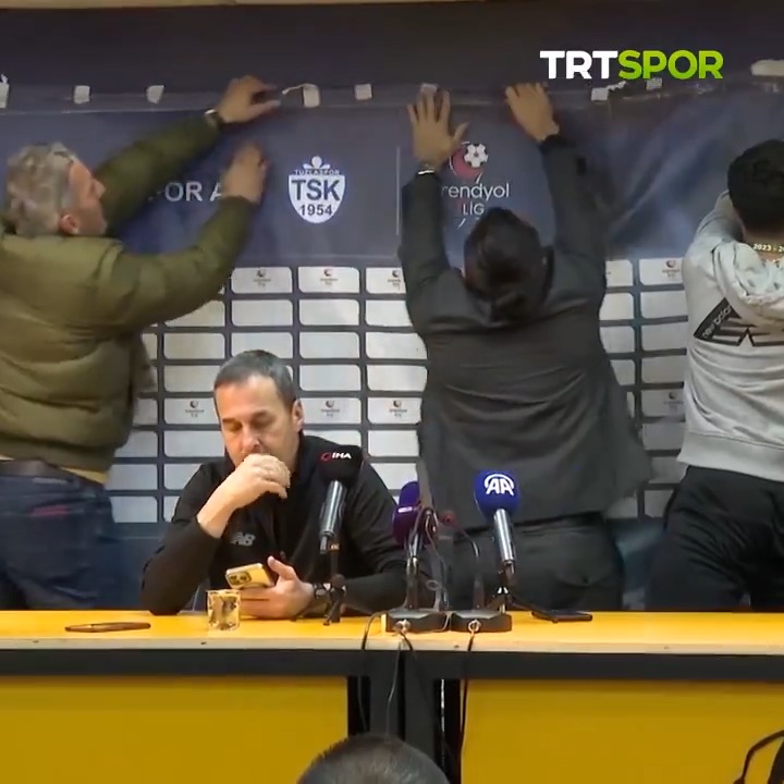 📸 Yalçın Koşukavak'ın basın toplantısı yaptığı yerde arka planda bulunan reklam panosunun değişiminde sorun yaşandı. 👥 Süper Lig'e ait reklam panosunu 1. Lig ile değiştirmek isteyen görevliler, sabitleyemedikleri panoyu basın toplantısı sırasında tutmak zorunda kaldı.