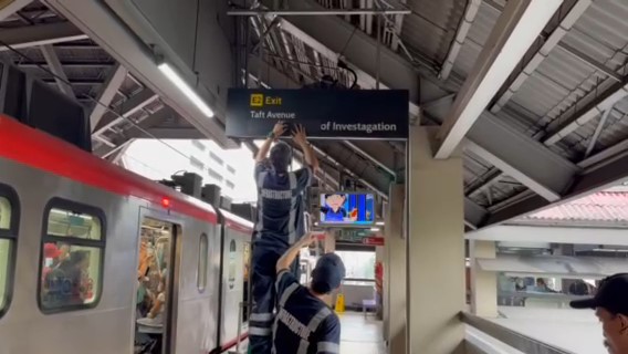 Workers at the LRT-1 line are seen covering a signage with wrong spelling at the Southbound side of LRT-1 UN Ave on Friday.
