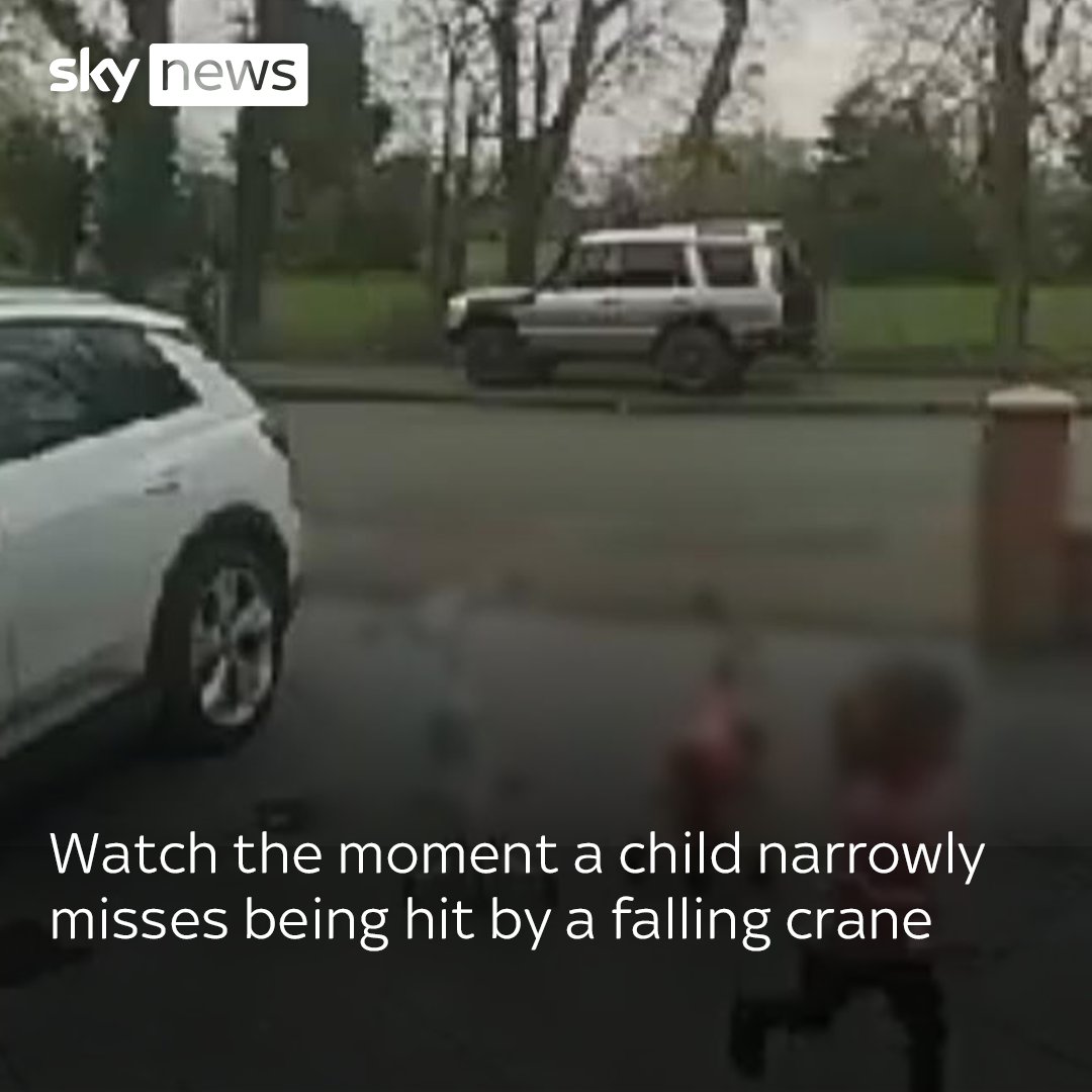 This doorbell cam footage shows the scary moment a crane tipped over and crashed through the driveway of a family home, narrowly missing a young child playing in front of the house ⏬