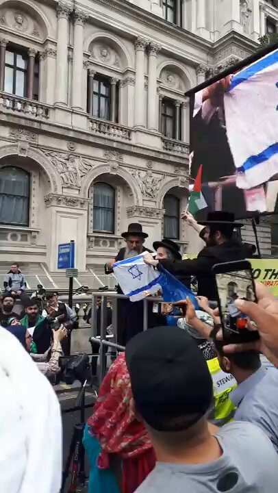 Jewish rabbis are burning the flag of the Nazi state of Israel.