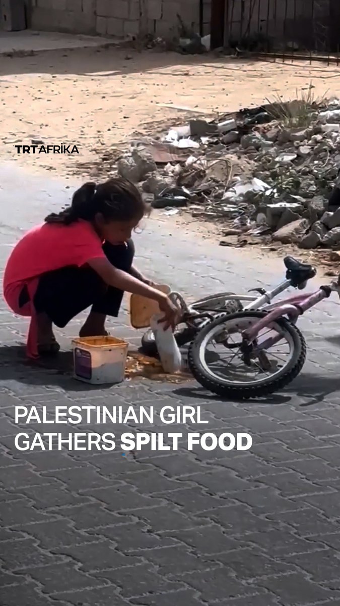 A young Palestinian girl attempts to scoop up food that she accidentally spilt while taking it back to her family, after waiting in line in Jabalia, northern Gaza, amid widespread hunger caused by Israel’s blockade on aid into the enclave