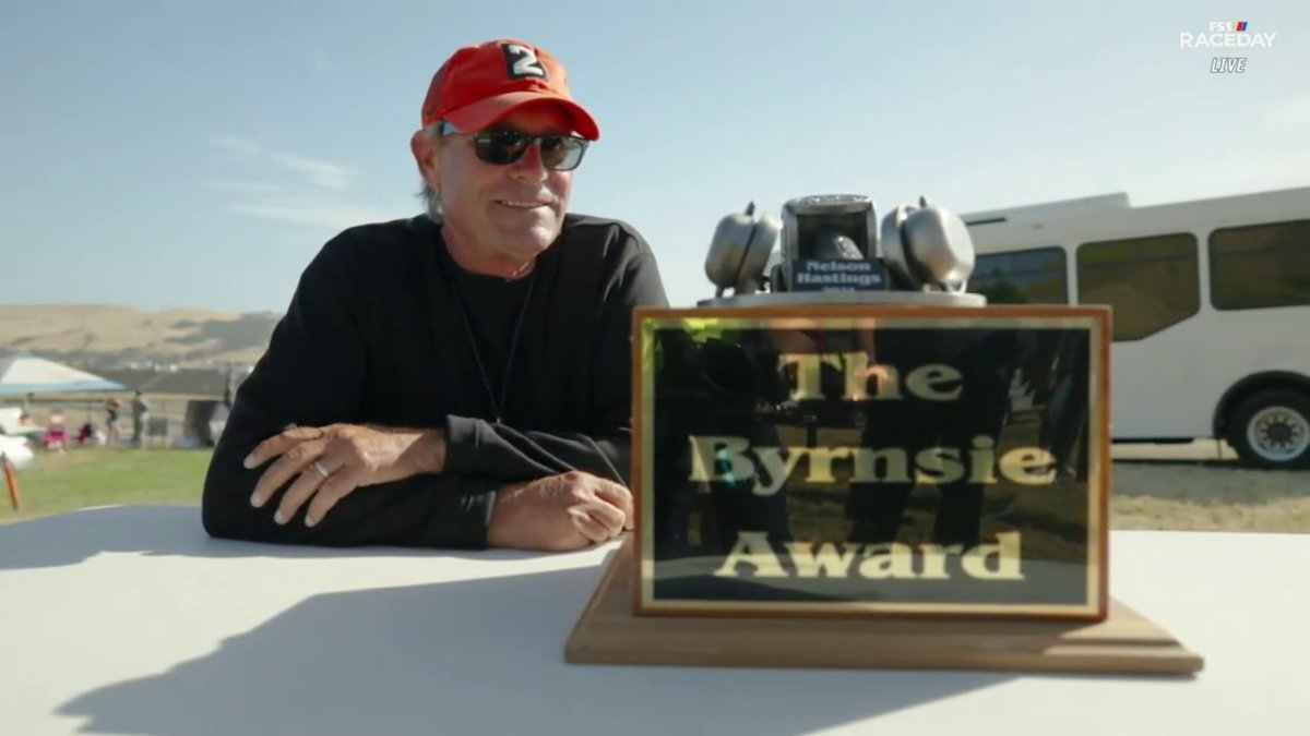 Bryson Byrnes, son of legendary NASCAR broadcaster Steve Byrnes, presents the 2024 Byrnsie Award to longtime FOX: NASCAR cameraman Nelson Hastings.