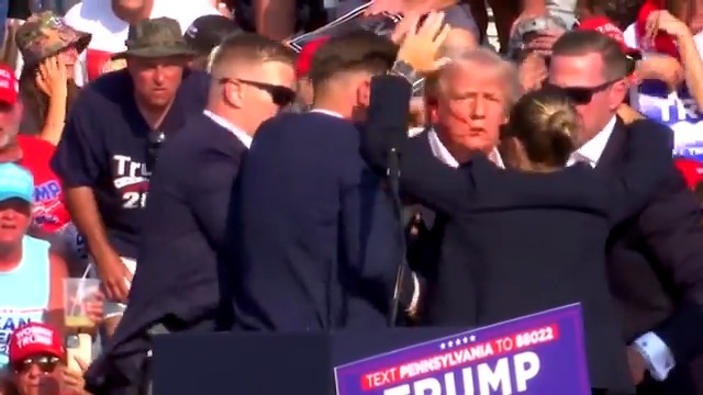 Gunfire erupted at a Donald Trump rally, sparking panic in the crowd and spattering the Republican presidential candidate with blood, before he emerged and defiantly pumped his fist in the air before being ushered to a waiting car
