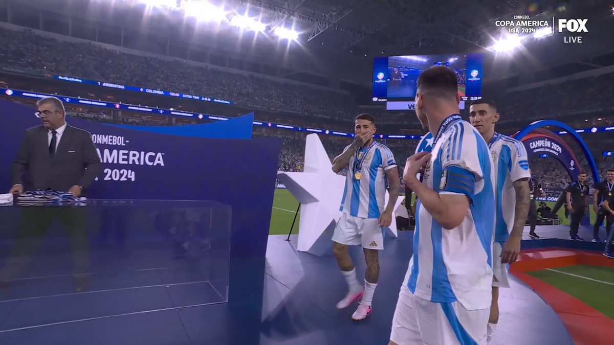 Messi flags Ángel Di María and Nicolás Otamendi over to help lift the trophy ❤️