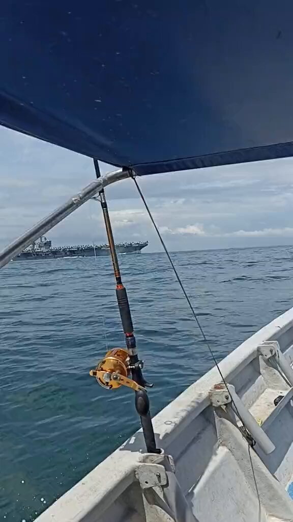 A ONCE IN A LIFETIME Malaysians fisherman in a civilian boat received a once in a lifetime experience seeing a US Navy nuclear-powered aircraft carrier CVN-71 USS Theodore Roosevelt sailing right in front of them in the Strait Of Malacca. It was said that the -