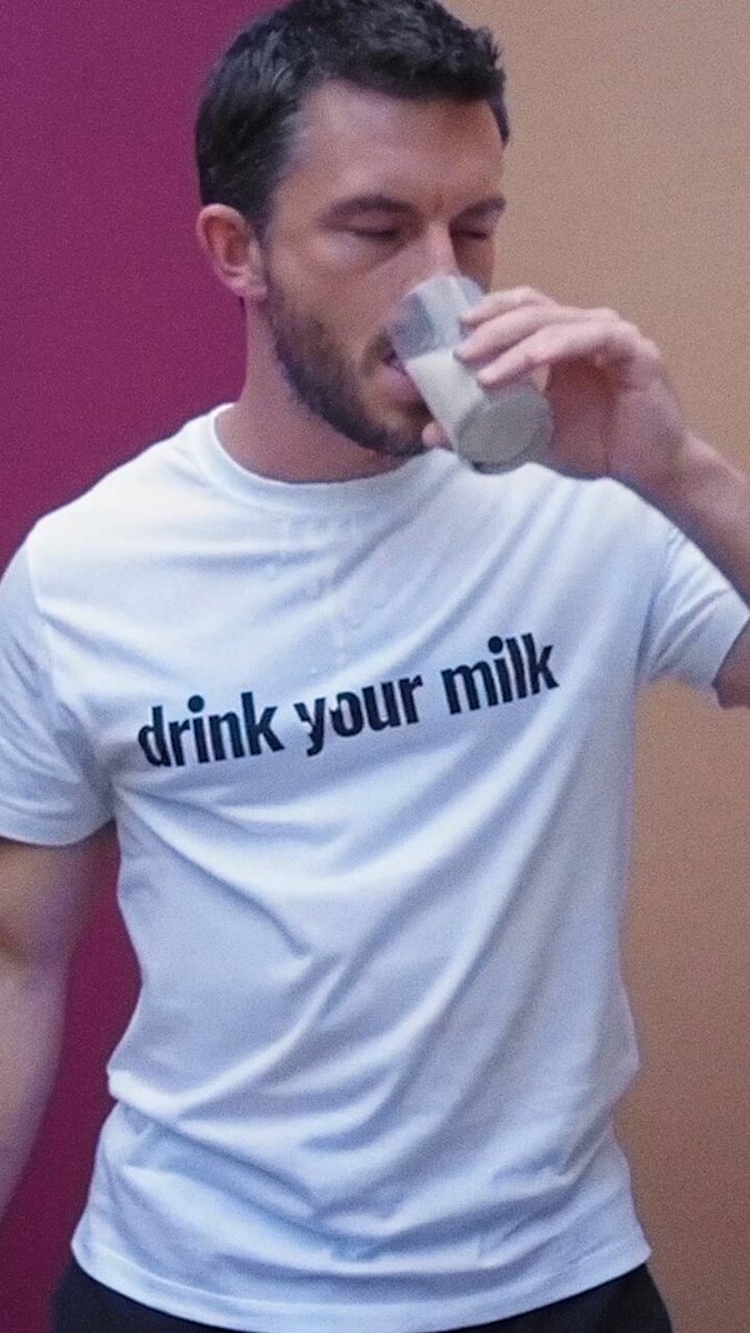 Jonathan Bailey drinking a glass of milk for LOEWE in association with The Shameless Fund.