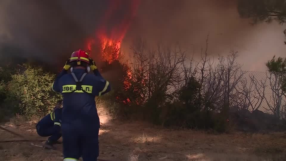 Residents fled their homes as a wildfire outside Athens burned trees, houses and cars and sent smoke clouds over the Greek capital