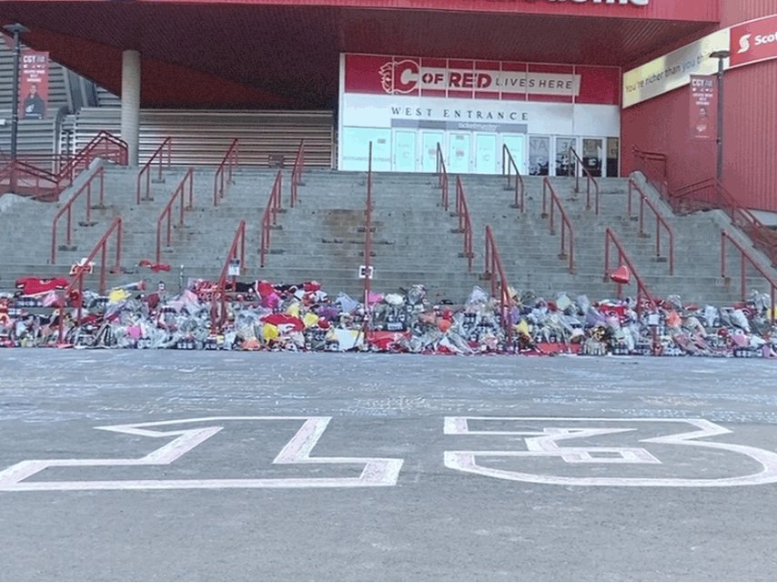 The memorial for Johnny Gaudreau at the Saddledome has grown a lot since last night. Lots of people here this Saturday morning. Dozens of messages in chalk. More candy, Gatorade, and notes.