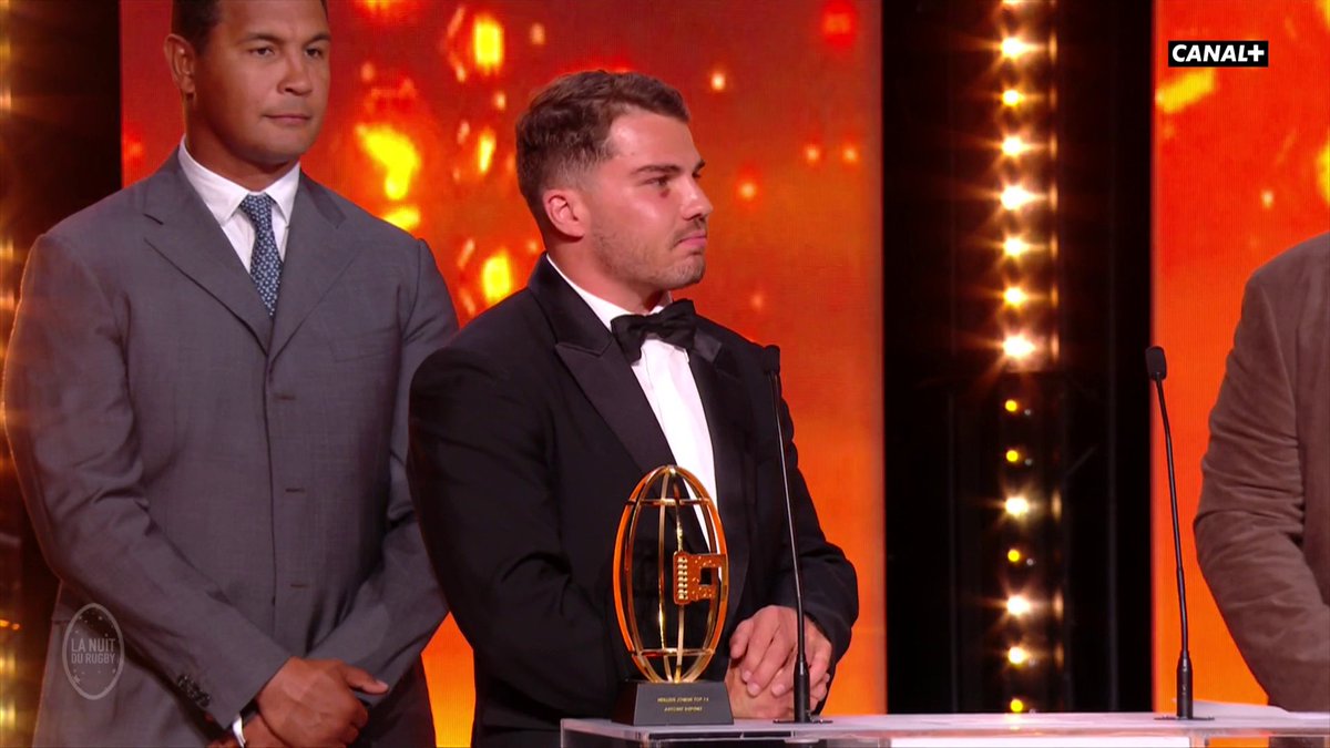 "Je mesure le privilège que j'ai de jouer dans ce club." Entouré de Serge Blanco et Thierry Dusautoir, Antoine Dupont reçoit le trophée de meilleur joueur du #TOP14. #NuitDuRugby