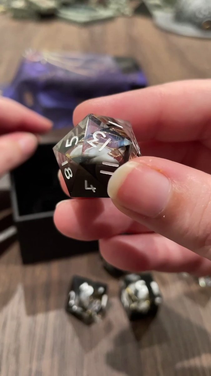 CAST YOUR FATE, ROLL THE DICE! 🪶 🎭 Unbox and explore the eerily gorgeous Matron of Ravens Dice Set from our friends at Everything Dice 🎲✨ with Lore Keeper Dani Carr, detailed with shimmering golden threads and masks fit for the Raven Queen! ✨ FIND YOURS 🎲 🇺🇸 🇪🇺