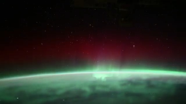 The International Space Station soars above an aurora blanketing the Earth underneath a starry sky before orbiting into a sunrise 257 miles above Quebec, Canada, on Oct. 30, 2024.