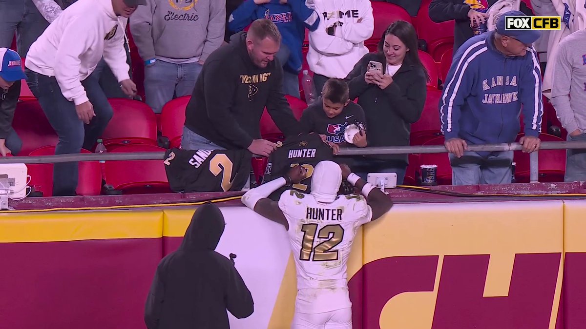 Travis Hunter takes time to sign a young fan's jersey after the tough Colorado loss