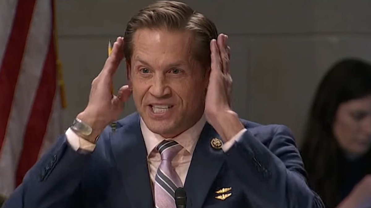 Postmaster General Louis DeJoy covers his ears during a House Oversight hearing while Rep. Rich McCormick (R-GA) criticizes the U.S. Postal Services' decline in reliability under his tenure.