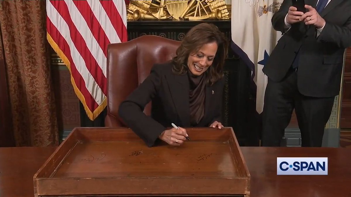 Vice President Kamala Harris adds her signature to the desk drawer in her ceremonial office, following a long tradition of outgoing vice presidents.