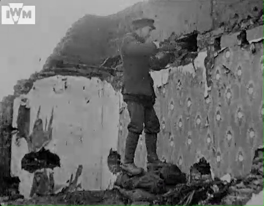 A Canadian sniper filmed firing from the ruins of a house's front room on the Western Front, February 1918. Film: IWM 255