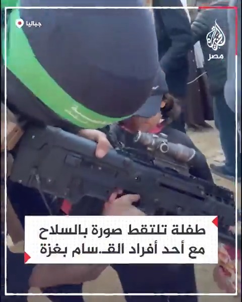 طفلة غزية تلتقط صورة بالسلاح مع أحد أفراد كتائب القسـ.ـام تزامنًا مع تسليم دفعة من الأسرى الإسرائيليين