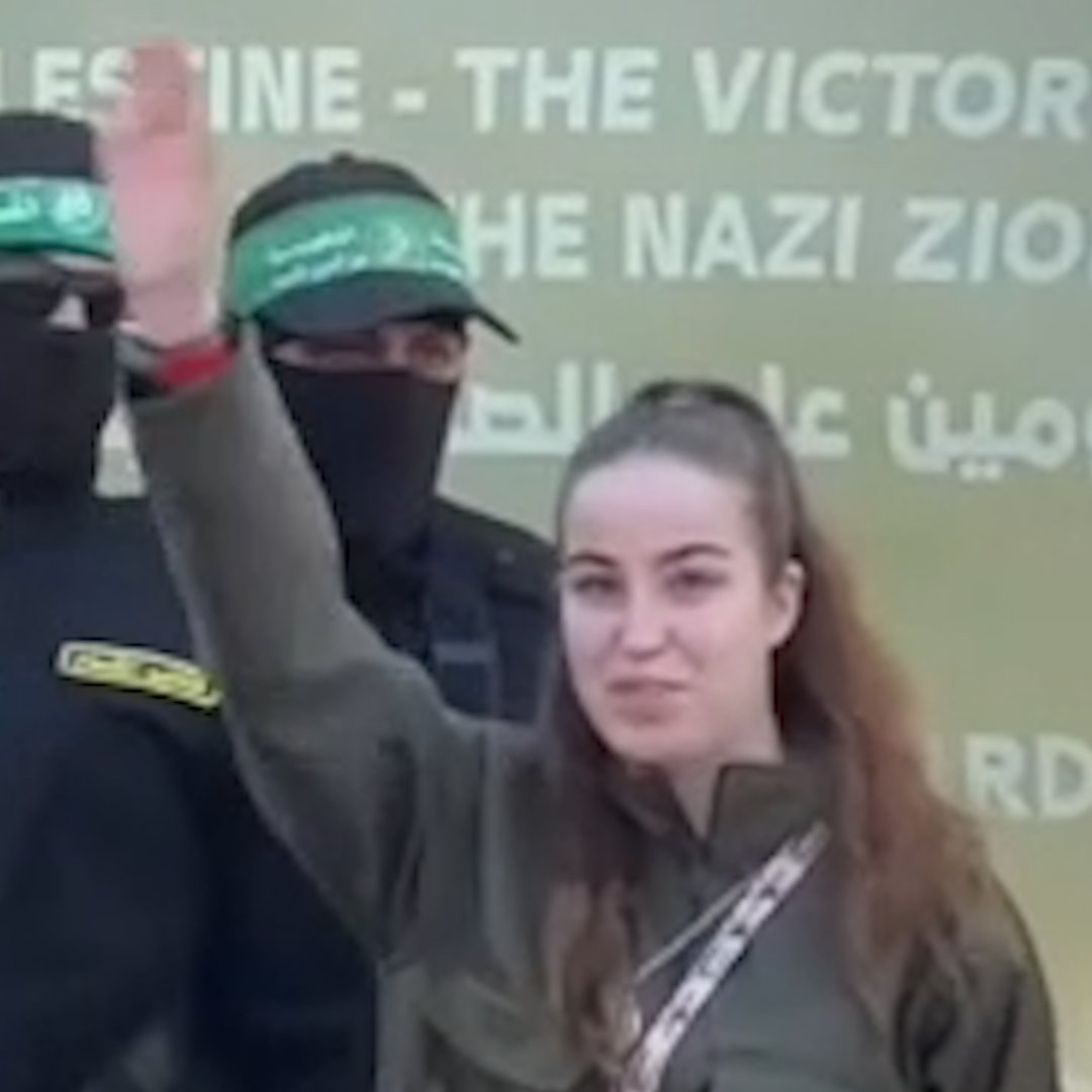 Israeli soldier Agam Berger waves to the crowd next to masked Islamic Jihad militants as she is handed over to the Red Cross at the Jabalya refugee camp in Gaza City.