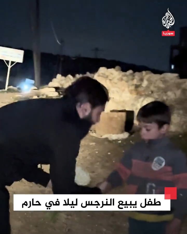 شاب يؤمن سترة لطفل يبيع النرجس ليلا في أحد طرقات مدينة حارم بريف #إدلب الشمالي #فيديو