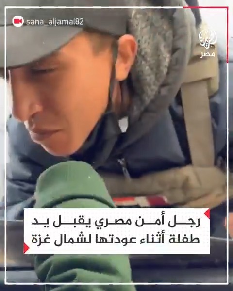 عنصر أمن مصري بلجنة التفتيش عند حاجز نتساريم وسط قطاع غزة يقبل يد طفلة عند مرورها في طريق العودة إلى الشمال