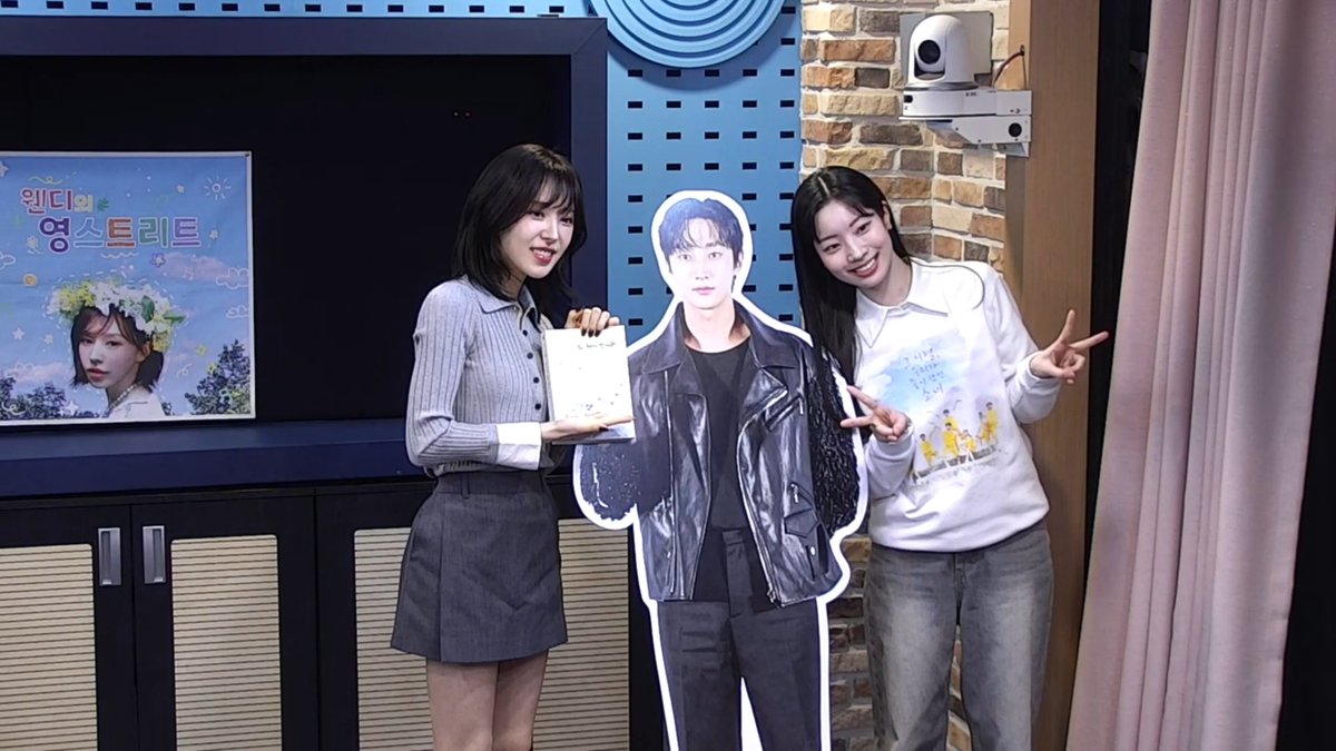 Dahyun and Wendy posing with Jinyoung's standee 😭