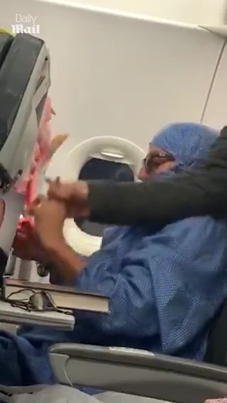 Woman detained by fellow passengers after smoking on a plane.