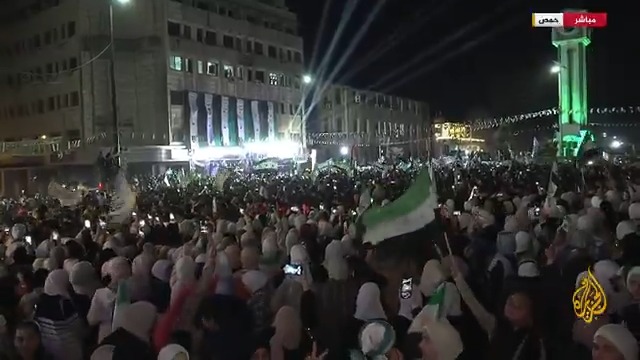 "الاحتفالات تمثل فرحة شعب عاد إلى الحياة".. الآلاف من أهالي مدينة حمص يحتشدون في ساحة الساعة احتفاء بالذكرى الأولى للثورة السورية بعد إسقاط حكم الأسد، فكيف تبدو الأجواء الاحتفالية؟ #الأخبار #الجزيرة_سوريا
