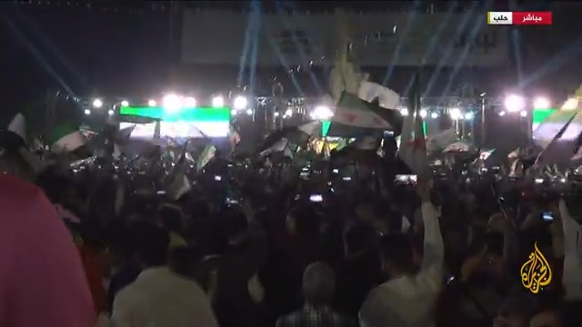 السوريون يحتشدون في ساحة سعد الله الجابري بمدينة حلب احتفاء بذكرى الثورة السورية.. مراسل #الجزيرة محمد الجزائري يرصد الأجواء الاحتفالية وأبرز الإجراءات الأمنية التي اتخذتها السلطات لضمان الأمن #الأخبار #الجزيرة_سوريا