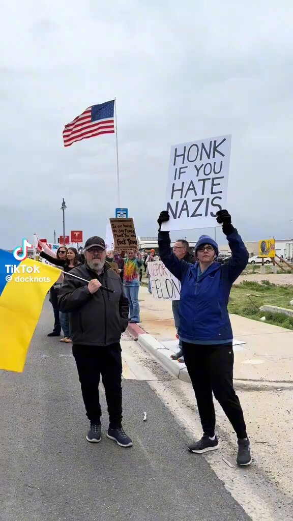 Funny to see banners "honk if you hate nazis" and Ukrainian flag nearby.