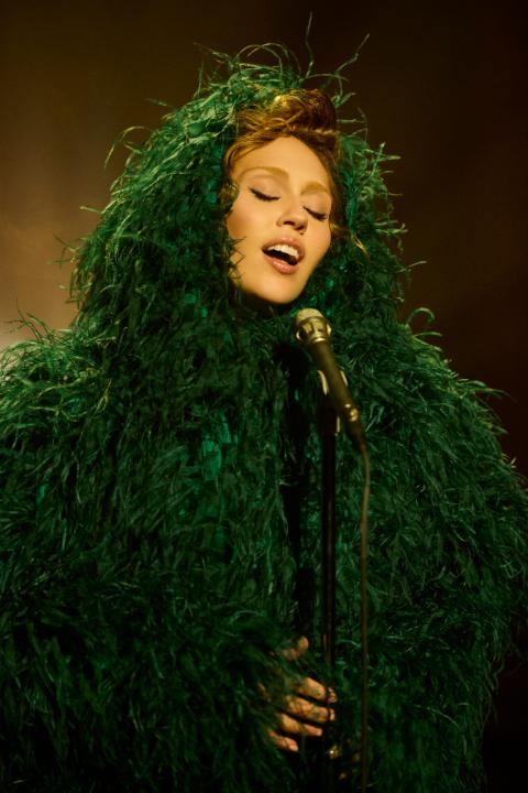 .Miley Cyrus wears a custom Mugler green embroidered feather coat and a green draped silk chiffon gown, designed for her new album, Something Beautiful - Special thanks to Bradley Kenneth - #mugler