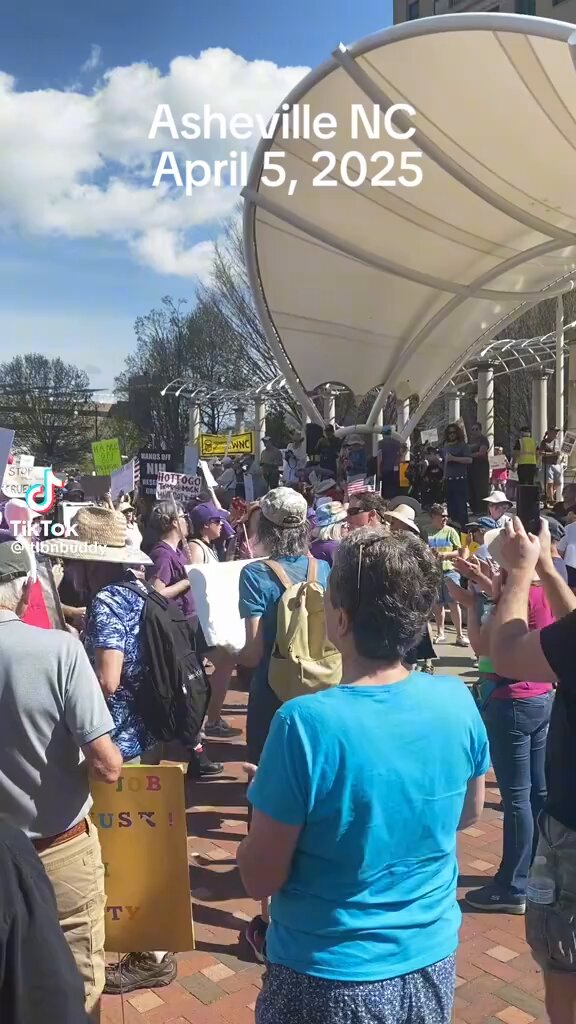 A large-scale rally opposing Elon Musk and Donald Trump is currently taking place in Asheville, North Carolina. The protesters are displaying signs featuring Nazi imagery and anti-immigrant messages directed at Elon Musk and Tesla.