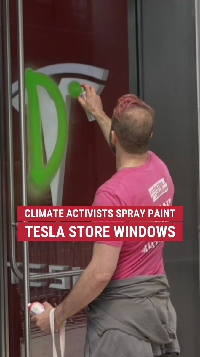 CAUGHT 'GREEN'-HANDED: Climate activists vandalize an NYC Tesla dealership with spray painted messages for their Earth Day protest.