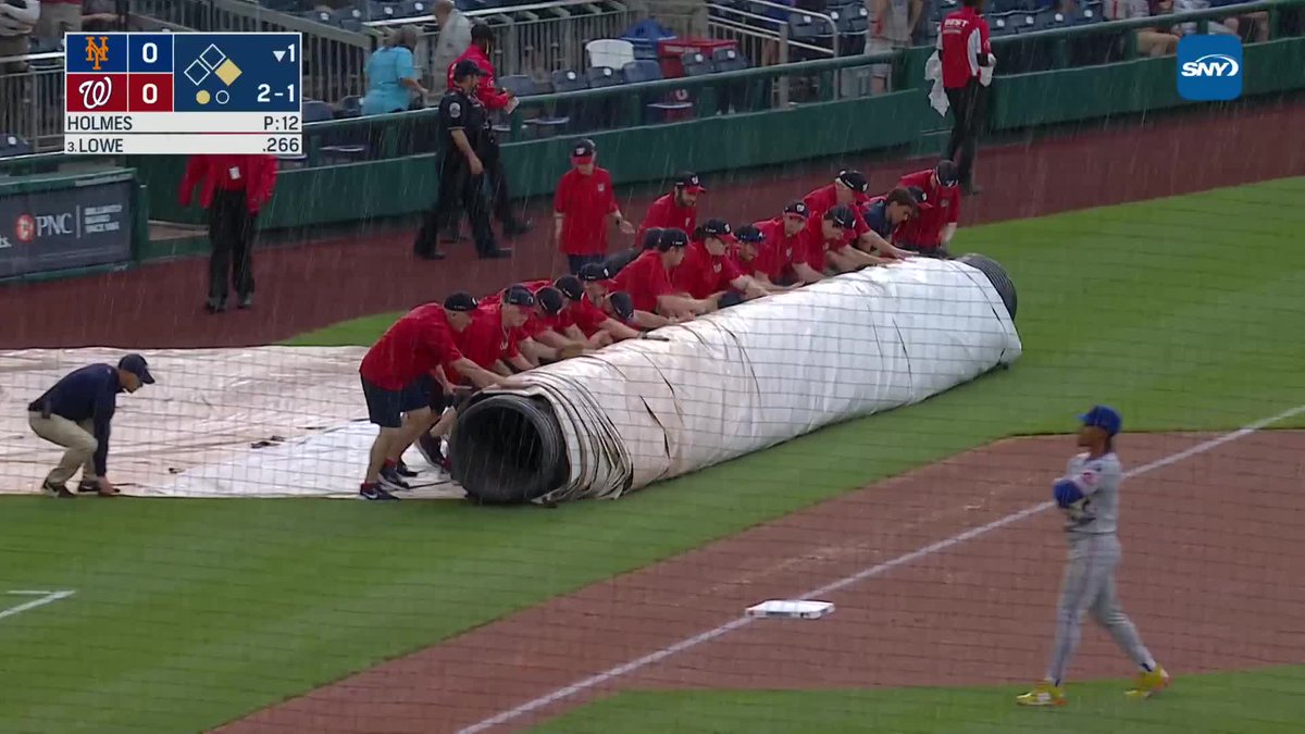 One of the Nationals' groundskeepers went down as the grounds crew put the tarp on the field