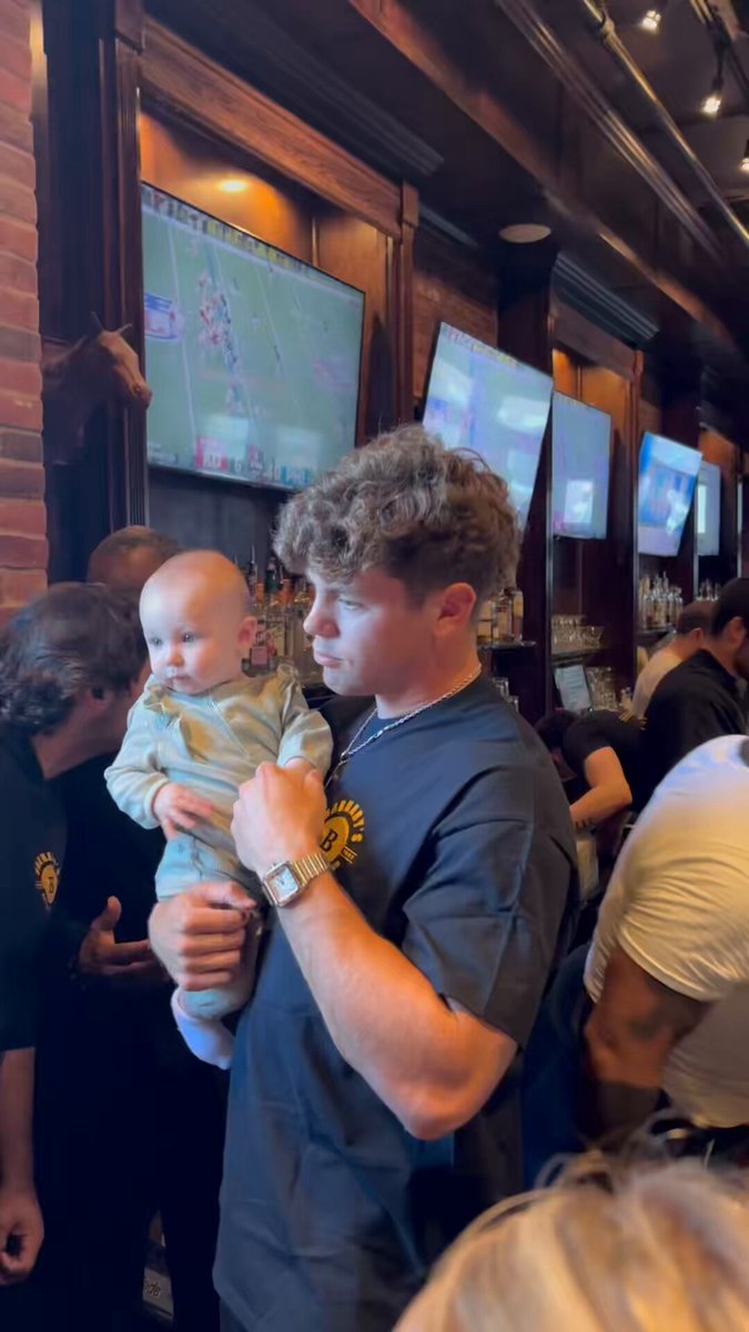 Cooper DeJean with a baby at a bar in Philly 🥹