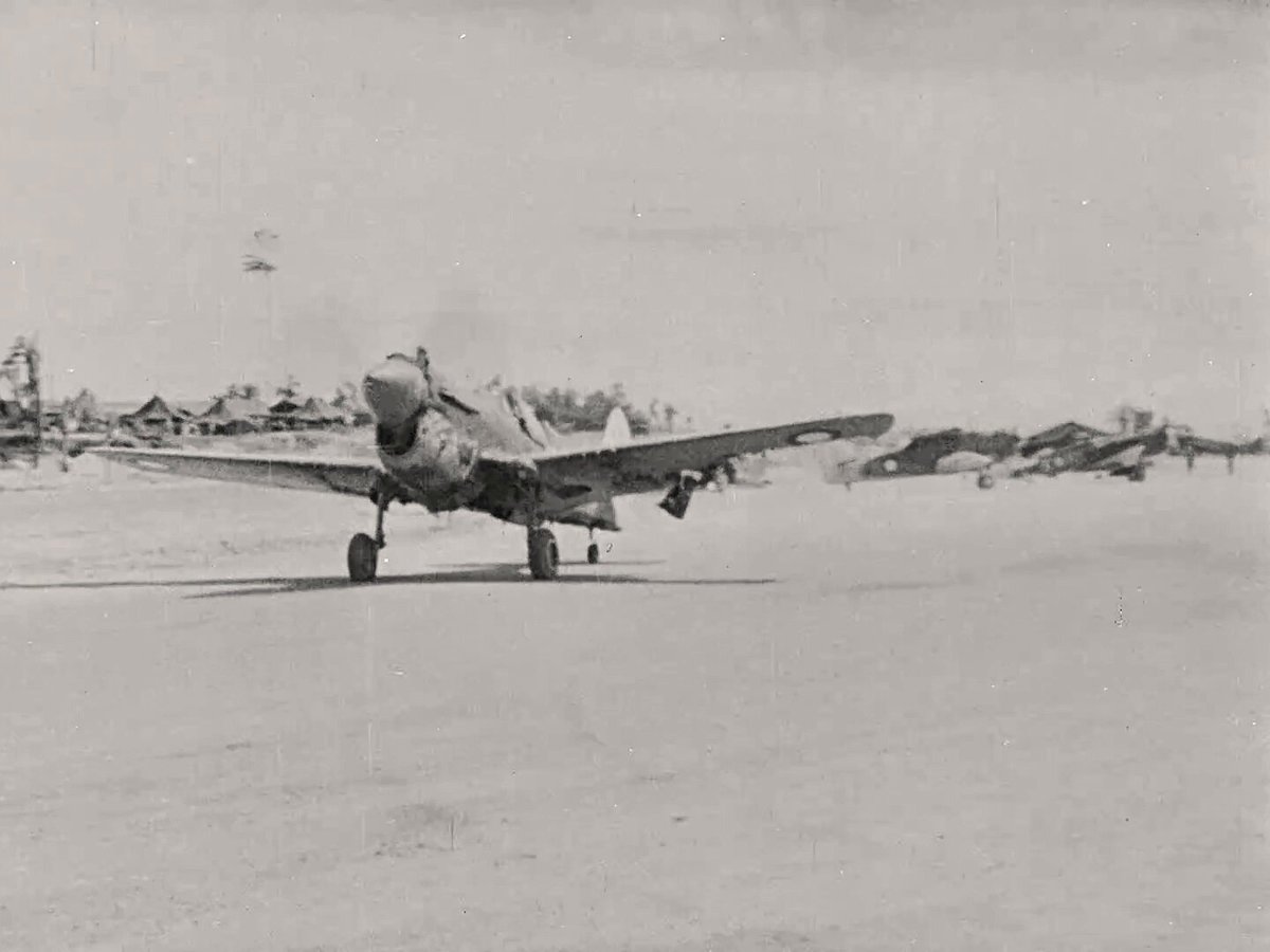 Flying Officer T.R. Jacklin with the damaged wing of his No. 75 Squadron RAAF Curtiss Kittyhawk Mk IV "SVENGALI" that made it back to base flying more than 300 kilometers after a direct hit by Japanese anti-aircraft fire on August 9th 1944