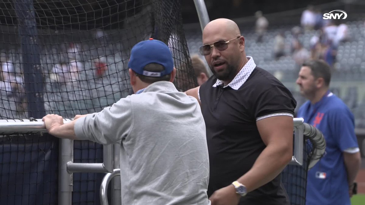 Carlos Beltrán talks with Steve Cohen behind the batting cage