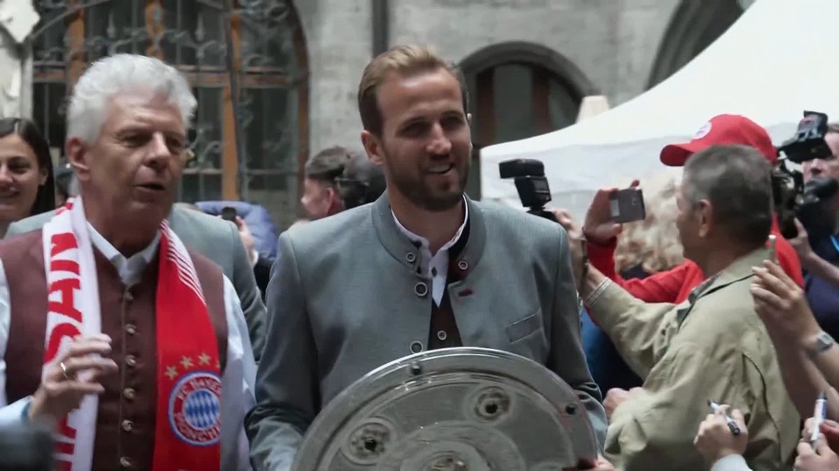 Harry Kane holds the Bundesliga trophy as Bayern Munich celebrate winning the title at a parade this afternoon ๐