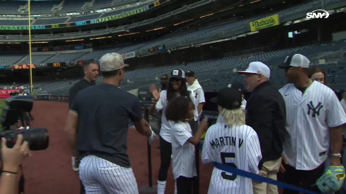 Anthony Volpe talks with Russell Wilson and Ciara on the field