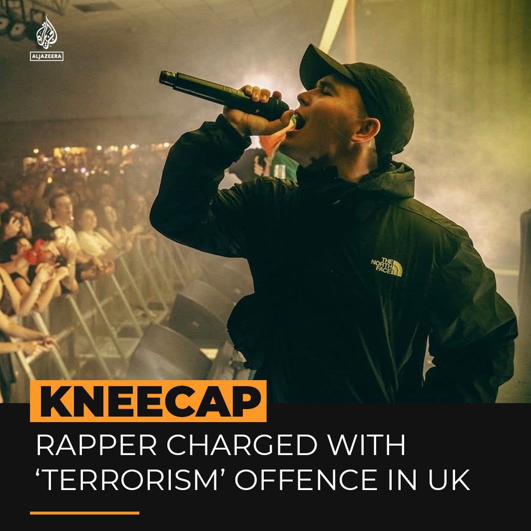 Kneecap band member Liam O’Hanna, known as Mo Chara, has been charged under the UK Terrorism Act for displaying a Hezbollah flag at a London concert in 2024. The rap group rejects the charge, accusing the UK of suppressing artists speaking out against Israel’s Gaza genocide.
